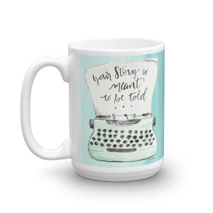 May include: White ceramic mug with a blue and green illustration of a typewriter with the text "Your story is meant to be told".