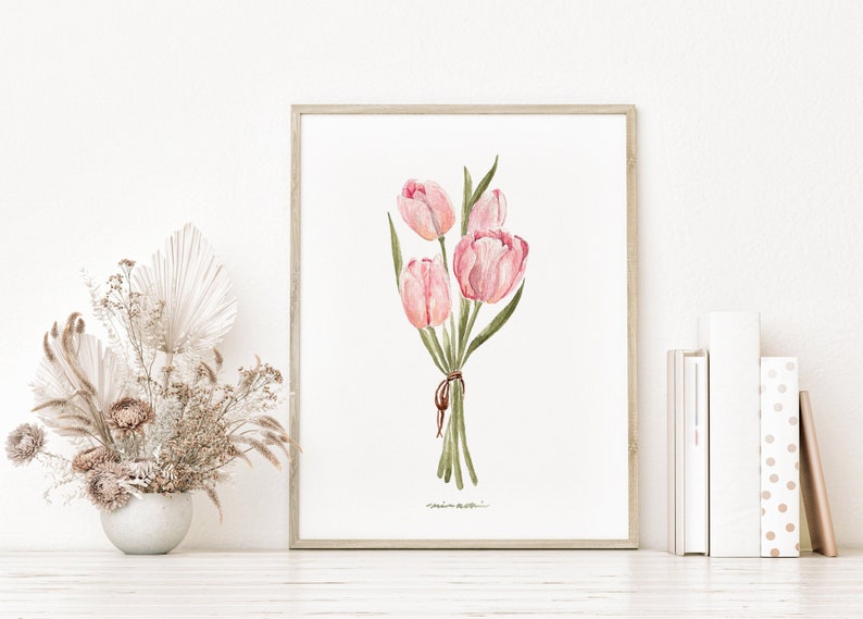May include: A framed watercolour painting of a bouquet of pink tulips with green stems and leaves. The tulips are tied together with a brown ribbon.