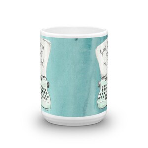 May include: White ceramic mug with a teal blue watercolor background. The mug features a vintage typewriter with a sheet of paper that reads "Your story is waiting to be told".