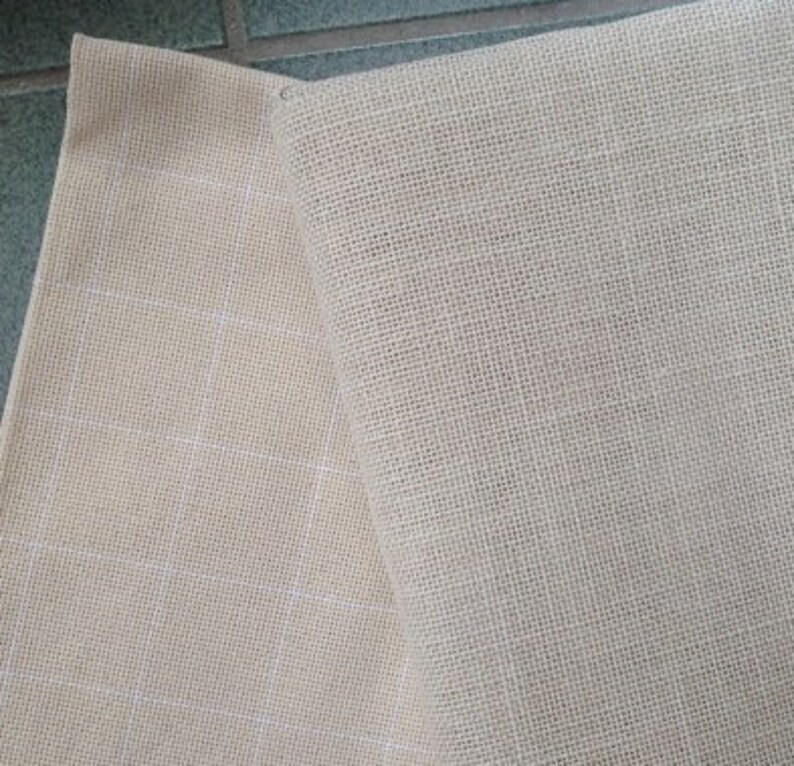 Puede incluir: Dos piezas de tela beige, una con un patr&oacute;n de cuadr&iacute;cula y la otra con una textura lisa.