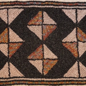 May include: Hand-hooked rug with a geometric design. The rug features a black background with repeating diamond shapes in beige and multi-colored sections. The border is a mix of colors, adding a decorative touch. This rug is suitable for home decor.
