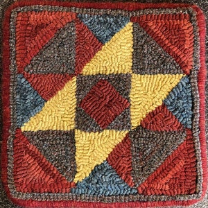 May include: A colorful rug with a geometric pattern of red, yellow, blue, and brown triangles. The rug is made of wool and has a textured surface.