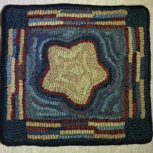 May include: A blue and brown rug with a star-shaped design in the center. The star is surrounded by a border of stripes in red, white, and blue.