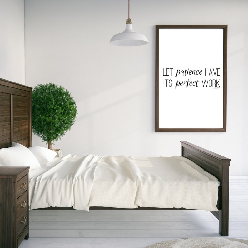 May include: A framed print with the text "LET patience HAVE ITS perfect WORK" in a bedroom setting with a bed, nightstand, and a potted plant.