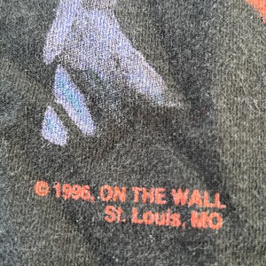 May include: Black t-shirt with red text that reads "&copy; 1996, ON THE WALL St. Louis, MO".