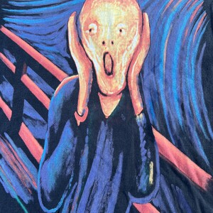 May include: A black t-shirt with a colorful print of Edvard Munch's The Scream painting. The painting features a figure with a pale face and a wide-open mouth, set against a swirling background of blue, red, and yellow.