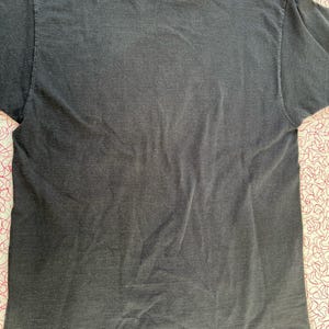 May include: A dark gray t-shirt with a faded look. The shirt is made of a soft, comfortable material.