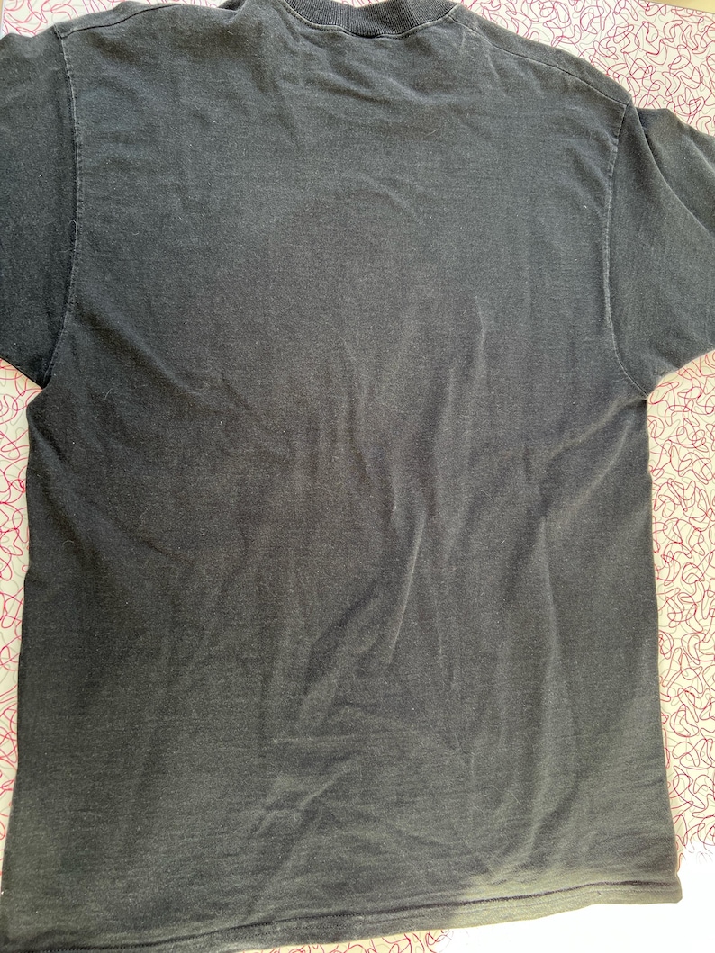 May include: A dark gray t-shirt with a faded look. The shirt is made of a soft, comfortable material.