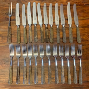 May include: A set of 18 vintage silverware pieces with brown wood-like handles. The set includes 12 forks and 6 knives.