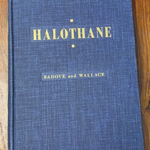 May include: A blue hardcover book with the title "HALOTHANE" in gold lettering and the authors "SADOVE and WALLACE" in smaller gold lettering.