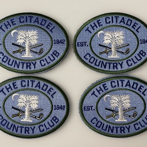 May include: Four blue and green oval embroidered patches with the text "The Citadel Country Club Est. 1842". Each patch features a white palmetto tree with a crescent moon and crossed swords and a golf club.