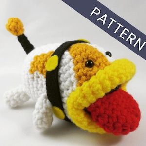 Può includere: Giocattolo per cani all'uncinetto in bianco, giallo e arancione con una lingua rossa. Il cane ha un collare nero con dettagli gialli e una coda nera. La parola "PATTERN" è stampata su uno striscione diagonale.