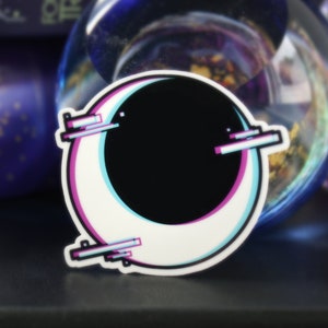 Może przedstawiać: Naklejka w kształcie półksiężyca w kolorze białym i czarnym z efektem błędu w kolorze różowym i niebieskim. Naklejka ma biały kontur i znajduje się na czarnej powierzchni.