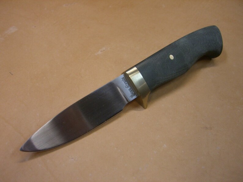 May include: A hunting knife with a black handle, brass bolster and a stainless steel blade. The blade has the text "Buck 119 Special" etched into it.