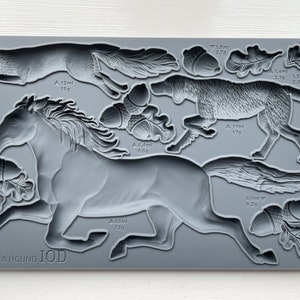 May include: Gray silicone mold with detailed impressions of a horse, fox, hound dog, and acorns. The mold is labeled "HORSE & HOUND IOD" and includes measurements in milliliters and grams.