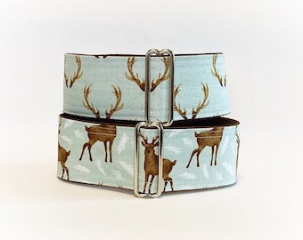 May include: A light blue dog collar with a brown deer print. The collar has a silver buckle and is made of two layers of fabric.