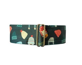 Puede incluir: Un collar para perros de color verde azulado oscuro con un estampado repetido de gorros de invierno en rojo, blanco y verde azulado. El collar tiene una hebilla de metal dorado. Los sombreros son de varios estilos, incluyendo gorros y gorros de punto.