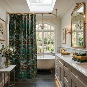 May include: A dark green shower curtain featuring a dense botanical pattern of white flowers, orange fruits, and blue birds, suspended from a curved brass rod in a bathroom with a white clawfoot tub, a marble vanity, and a gold-framed mirror.
