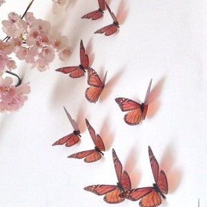 May include: A set of 10 orange and black butterfly wall decals. The butterflies are arranged in a diagonal line, with the largest butterfly at the bottom.