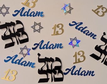 Może przedstawiać: Zestaw konfetti imprezowego zawierający niebieskie wycinanki z imieniem Adam, złote cyfry 13, czarne litery hebrajskie oraz małe srebrne holograficzne gwiazdy Dawida rozrzucone na powierzchni.
