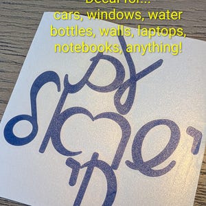 Könnte beinhalten: Ein dunkelblauer Vinyl-Aufkleber mit stilisierter Schreibschrift auf weißem Untergrund. Der Text lautet: Decal for... cars, windows, water bottles, walls, laptops, notebooks, anything! Das Design besteht aus miteinander verbundenen, fließenden Buchstaben.