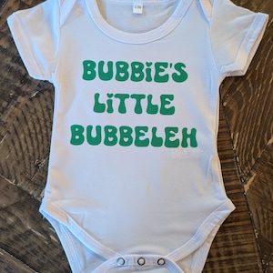 May include: A set of three ceramic mugs with a speckled, matte finish. The mugs are in shades of cream, light gray, and dark gray. Each mug has a simple, minimalist design, perfect for coffee or tea.