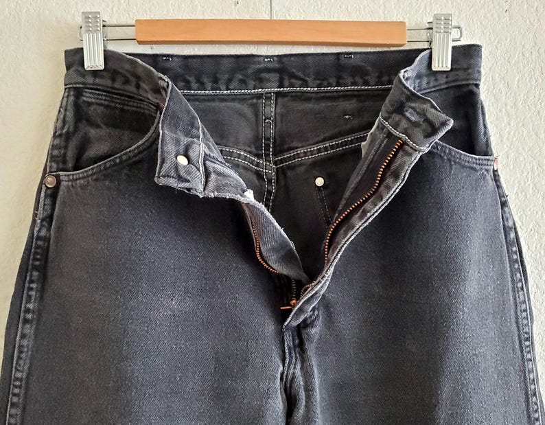 May include: A pair of black denim jeans with a zipper fly and button closure. The jeans have a classic five-pocket style and are made of a soft, comfortable fabric.