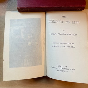 Może przedstawiać: Otwarta książka zatytułowana "The Conduct of Life" autorstwa Ralpha Waldo Emersona z wstępem autorstwa Andrew J. George'a, M.A. Książka została wydana w Nowym Jorku przez Thomas Y. Crowell & Co.