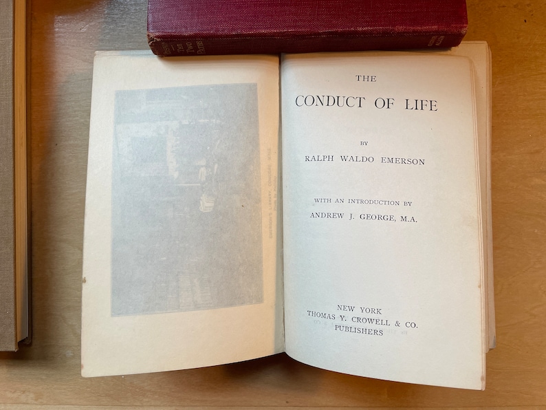 Może przedstawiać: Otwarta książka zatytułowana "The Conduct of Life" autorstwa Ralpha Waldo Emersona z wstępem autorstwa Andrew J. George'a, M.A. Książka została wydana w Nowym Jorku przez Thomas Y. Crowell & Co.