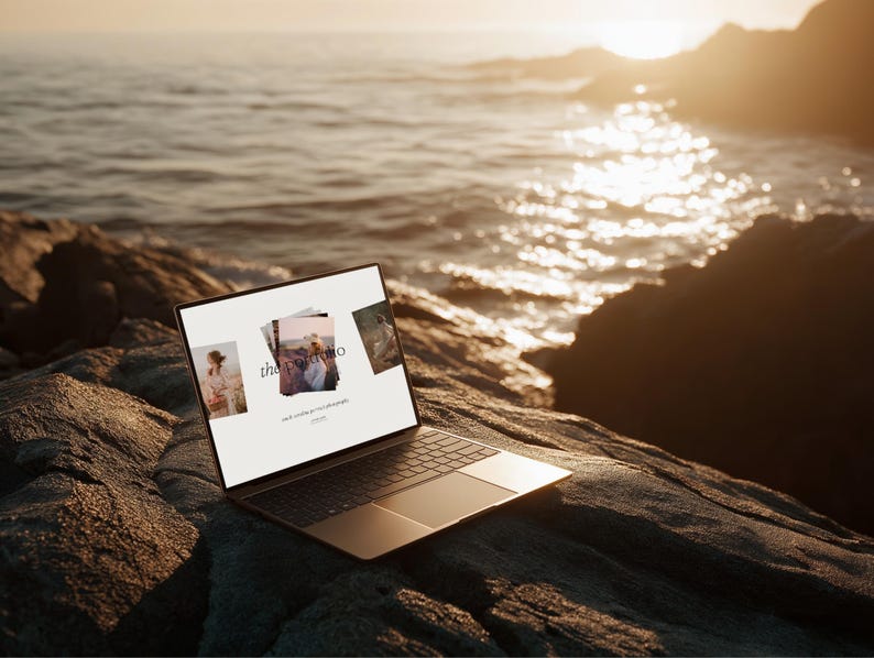 May include: A laptop computer with a black keyboard and a silver-colored frame is open on a rocky surface near the ocean. The screen displays three images and the text "the portfolio" with additional text below. The background features the ocean and a sunset.