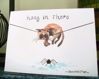 May include: A watercolor illustration of a cat hanging from a clothesline with the text "hang in there". A spider is on the ground below the cat. The artist's signature "~Dreana13~" is in the bottom right corner.