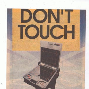 May include: A vintage advertisement for the U-Force controller for the Nintendo Entertainment System. The ad features a black and gray controller with a screen and the text "DON'T TOUCH" in large, bold letters. The ad also includes the text "Introducing U-Force, the revolutionary controller for your Nintendo Entertainment System. So hot, no one can touch it."