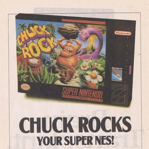 May include: A video game cartridge for the Super Nintendo Entertainment System featuring Chuck Rock, a green, prehistoric, cartoon character. The game box art shows Chuck Rock holding a rock above his head, with a purple dinosaur in the background. The text on the box reads "Chuck Rock" and "Super Nintendo Entertainment System".