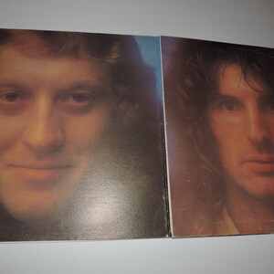May include: Close-up of a vintage vinyl record album cover featuring two men with long hair. The men are looking directly at the camera. The album cover is a warm brown color.