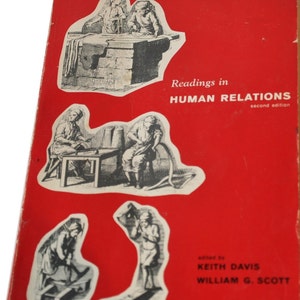 以下が含まれることがあります： 「人間関係における読解、第二版」というタイトルと、編集者であるキース・デイビスとウィリアム・G・スコットの名前が書かれた赤い本の表紙。表紙には、働く人々の白黒のイラストが描かれている。