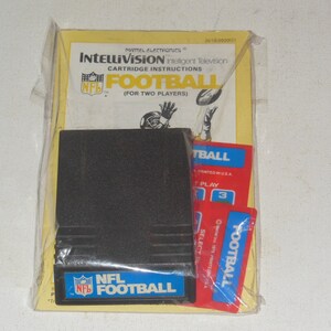 May include: A black Intellivision game cartridge for NFL Football, packaged in a yellow and white cardboard box with instructions. The box features a red NFL logo and a football player throwing a football.