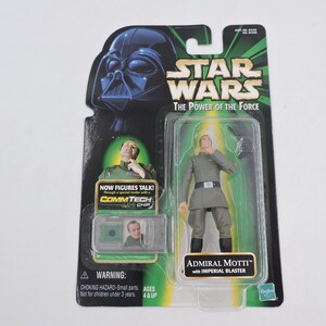 Könnte beinhalten: Star Wars Admiral Motti Actionfigur in Originalverpackung. Die Figur trägt eine graue Uniform und wird mit einem Imperial Blaster geliefert. Die Verpackung zeigt Darth Vader und den Text "The Power of the Force."