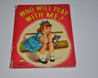 Könnte beinhalten: Ein altes Kinderbuch mit dem Titel "Wer will mit mir spielen?" zeigt ein junges Mädchen in einem blauen Kleid, das auf einer Bank mit einem Kätzchen sitzt. Der Einband des Buches ist rot mit einem gelben Sonnenstrahl hinter dem Mädchen und dem Kätzchen.