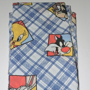 Könnte beinhalten: Ein blauer und weißer karierter Stoff mit Comicfiguren aus Looney Tunes. Die Figuren sind Tweety Bird, Sylvester die Katze und Bugs Bunny.
