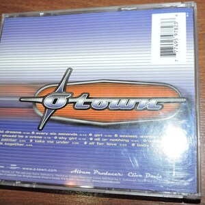 May include: A blue and orange CD case with the band name "O-Town" printed in white. The back of the case lists the song titles "Liquid Dreams", "Every Six Seconds", "Love Should Be a Crime", "The Painter", "Shy Girl", "Take Me Under", "Girl", "All or Nothing", "All for Love", and "Baby" with their corresponding lengths. The album producer is listed as "Clive Davis".