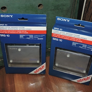 May include: Two blue and white boxes with the Sony logo and the text "SRS-10 Stereo Active Speaker System" on the front. The boxes contain a small, silver cassette player with the Sony logo on the front. The boxes are labeled "Walkman" on the bottom.