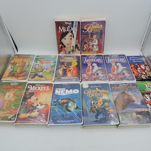 Pu&ograve; includere: Una collezione di VHS Disney con film d'animazione come "Mulan", "La Bella e la Bestia" e "Alla ricerca di Nemo". Le cassette presentano copertine colorate con illustrazioni dei personaggi.