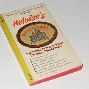 May include: A yellow and red book titled "Heloise's Kitchen Hints" with a picture of a stove on the cover. The book is a storehouse of new tricks for every housekeeper.