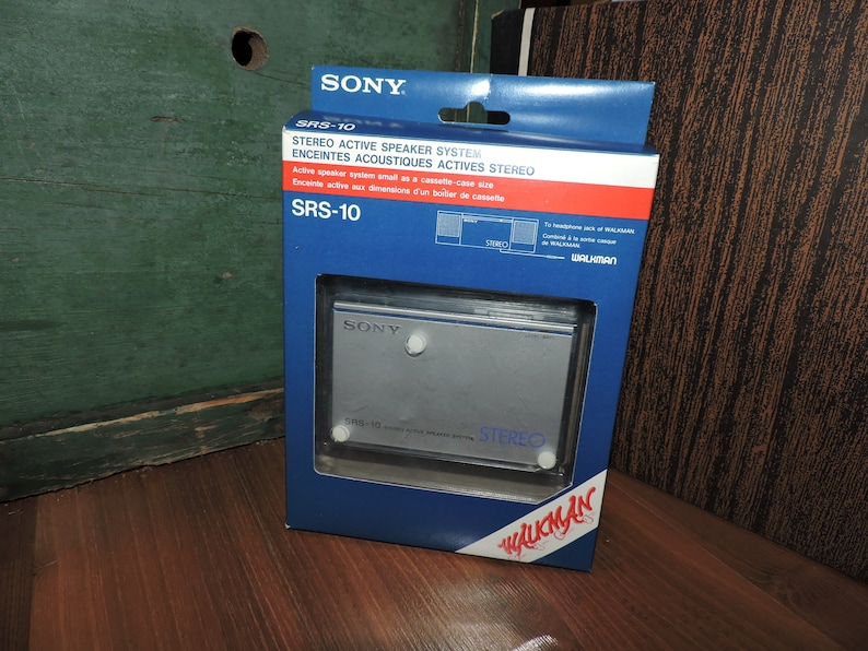 May include: A blue and white box for a Sony SRS-10 stereo active speaker system. The box features the text "SRS-10" and "STEREO ACTIVE SPEAKER SYSTEM" in white lettering. The box also includes a picture of the speaker system, which is silver and has the text "SONY" and "STEREO" on it.