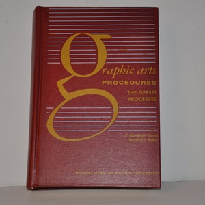 Könnte beinhalten: Ein rotes Buch mit einem goldenen "G" auf dem Einband. Der Titel lautet "Graphic Arts Procedures: The Offset Processes" von R. Randolph Karch und Edward J. Buber. Das Buch enthält Kapitel über Kunst und Filmkomposition.