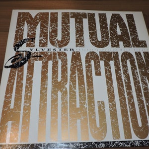 May include: A white vinyl record with a gold and black design. The record is titled "Mutual Attraction" and features the artist "Sylvester".