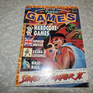 May include: A magazine cover for Video Games, issue 11/92, featuring a colourful illustration of a character from the video game Street Fighter II. The cover text reads "Video Games" and "Street Fighter II".
