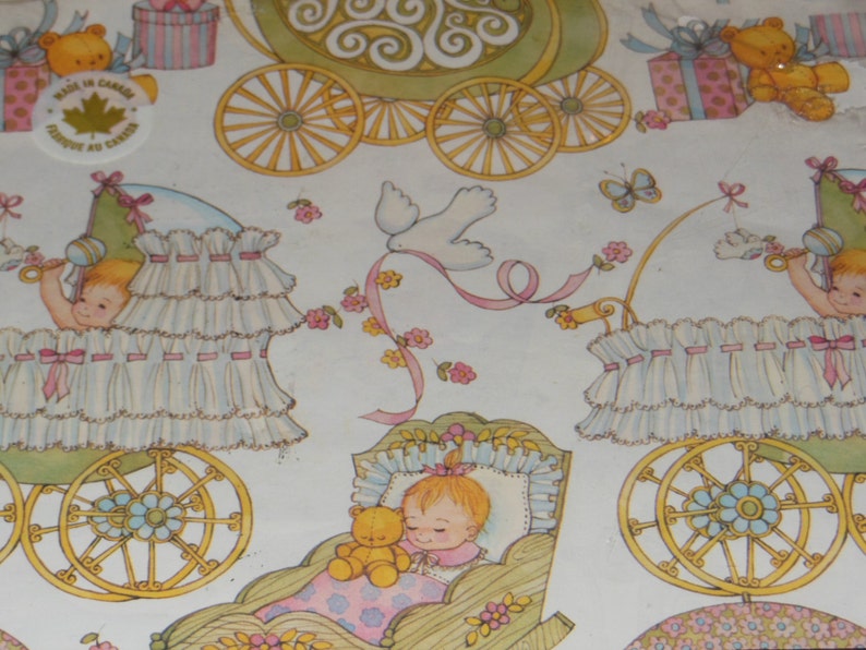May include: A white and pink baby carriage with a white lace trim and a pink ribbon. The carriage is decorated with flowers and a small teddy bear. The carriage is on a white background with a pink and blue border. The text "Made in Canada" is printed on the image.