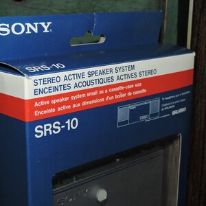 May include: A blue and red box with the text "SONY" and "SRS-10" printed on it. The box is for a stereo active speaker system that is the size of a cassette case. The box also has a picture of the speaker system on it.