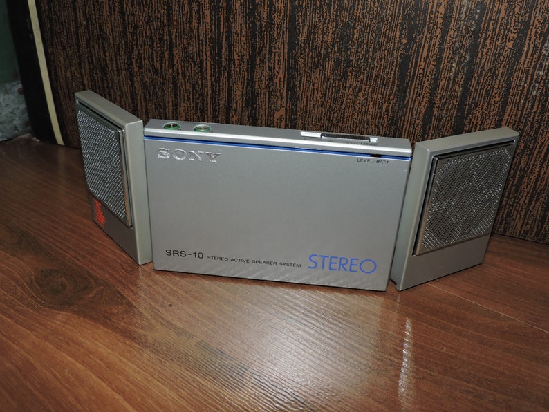 May include: A silver Sony SRS-10 stereo active speaker system with a blue label and the text "STEREO" on the front. The system has two detachable speakers.